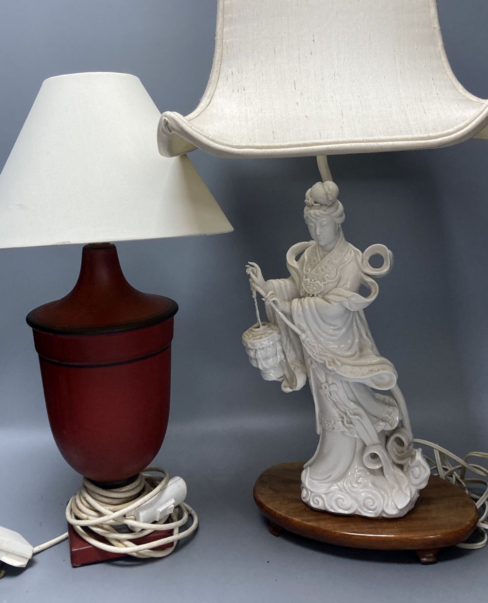 A Chinese blanc de chine porcelain table lamp, modelled as Guanyin, 65cm high including shade and a toleware vase shaped table lamp (2)